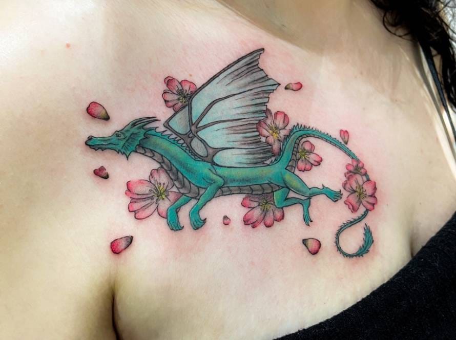 Turquoise draak met roze bloesems op de borst.