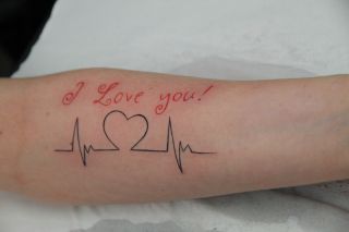 Rode tekst 'I Love you!' met zwarte hartslaglijn op onderarm.