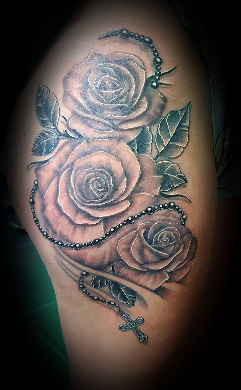 Zwart-wit tattoo van drie rozen met een rozenkrans en kruis.