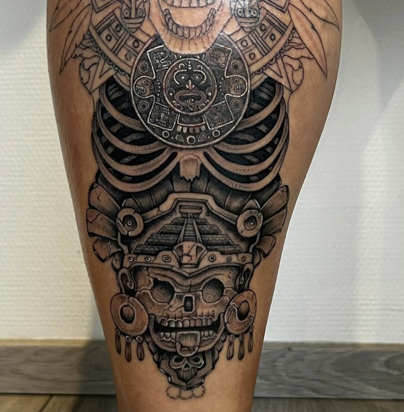 Gedetailleerde Azteekse schedel en kalender op onderbeen.