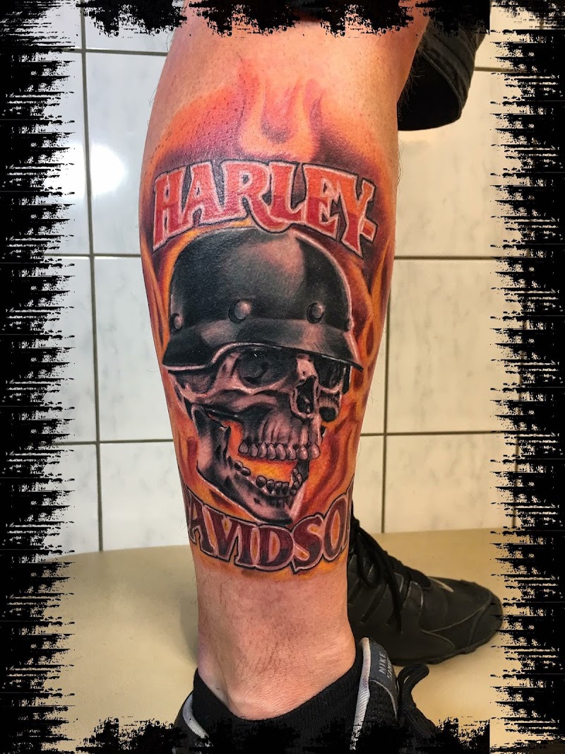 Schedel met helm, vlammen en Harley Davidson tekst op onderbeen.