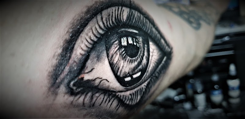 Realistisch oog tattoo in zwart-wit op de arm.