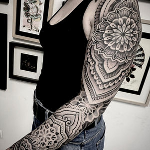 Grote mandala sleeve tattoo in dotwork en geometrische stijl op de hele arm.
