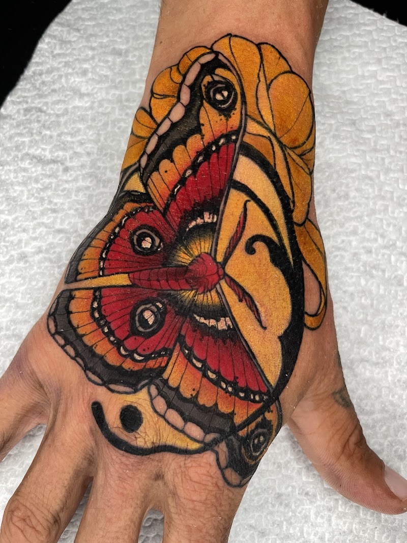 Neo-traditional mot met gezichtsprofiel op hand.