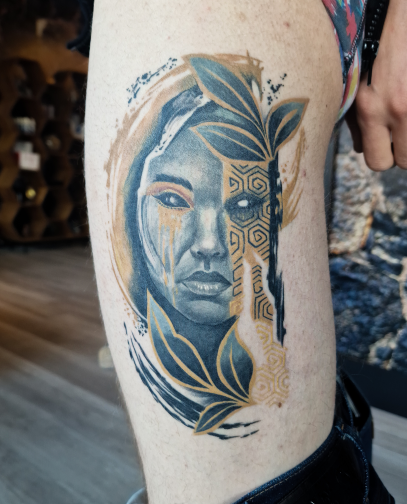 Portret tattoo van vrouw met geometrische patronen en bladeren op bovenbeen.