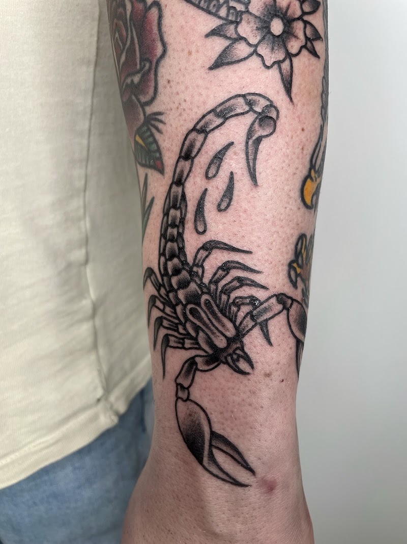Zwart-witte traditionele schorpioen tattoo op de onderarm.