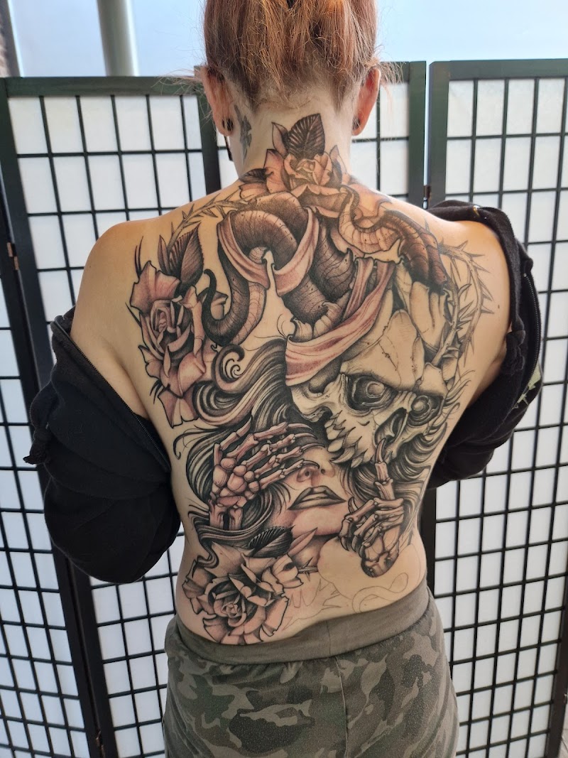Grote neo-traditionele rugtattoo met schedel, vrouw, rozen en slang.