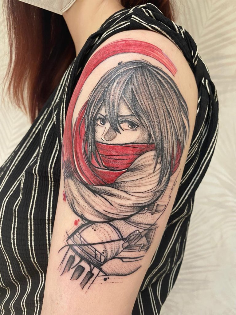 Illustratieve tattoo van Mikasa Ackerman met rode sjaal op bovenarm.