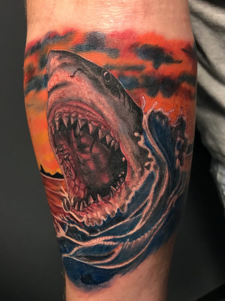 Realistische haai die uit het water springt bij zonsondergang.