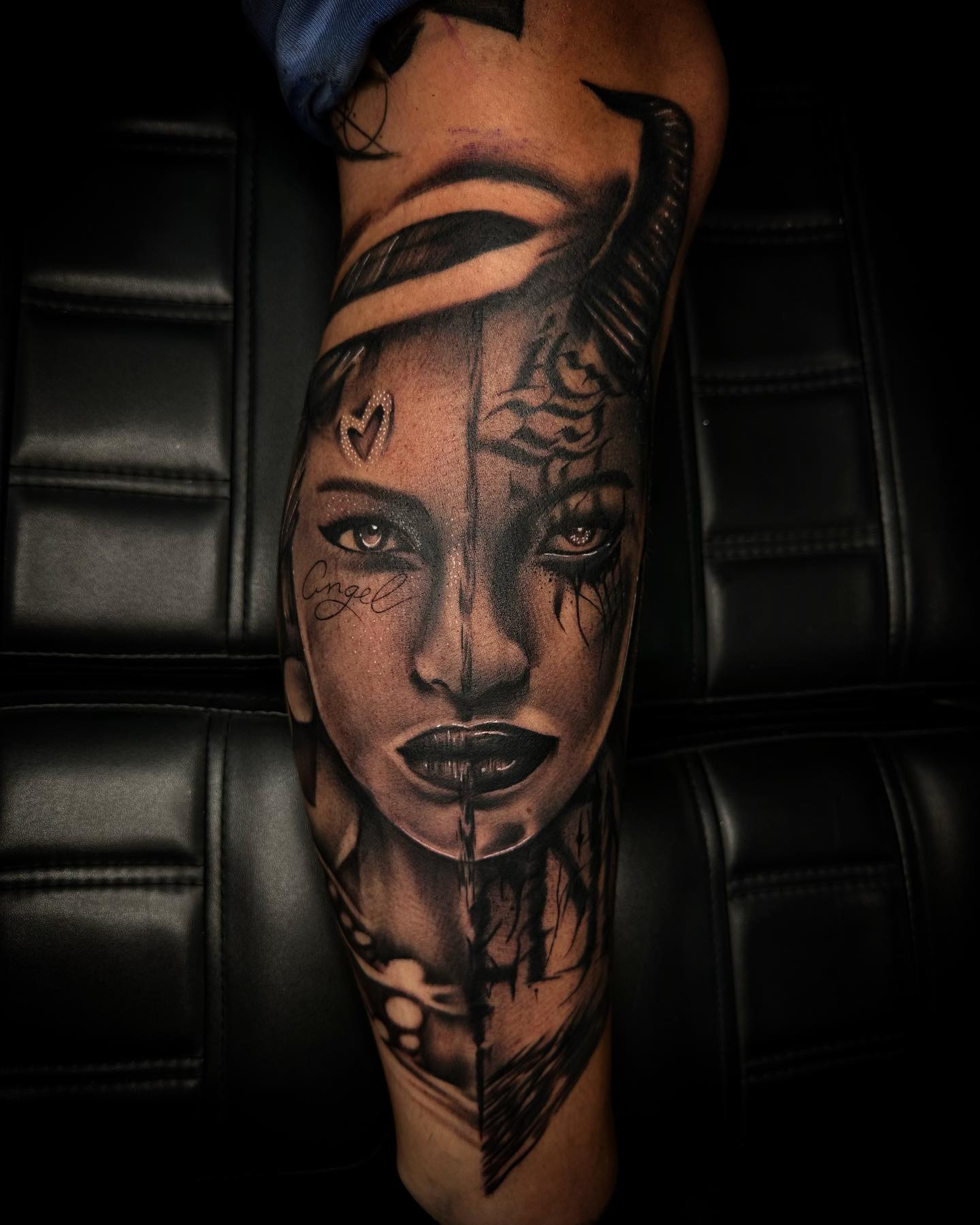 Realistisch portret van een vrouw, half engel half duivel, op het onderbeen.