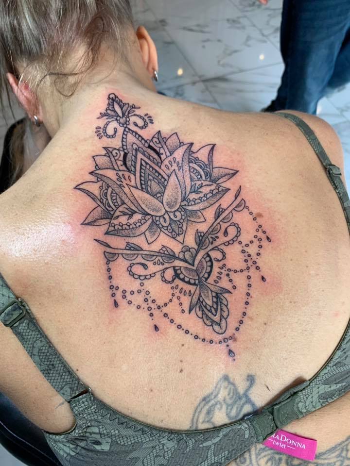 Sierlijke lotusbloem met ornamenten en hangende details op de bovenrug.