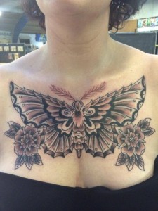 Grote traditionele mot met bloemen op de borst.