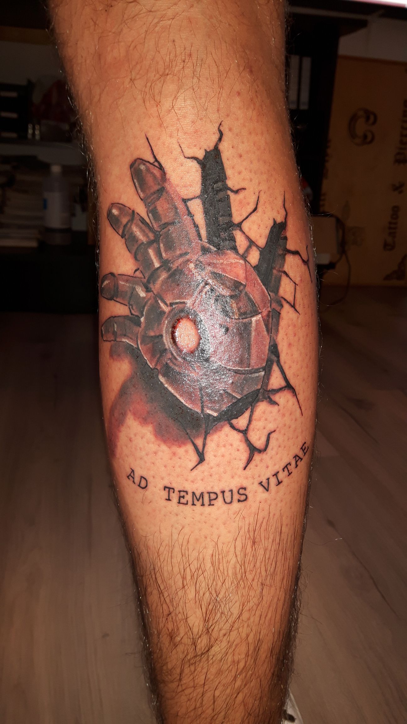 Realistische mechanische hand die door huid breekt met Latijnse tekst.