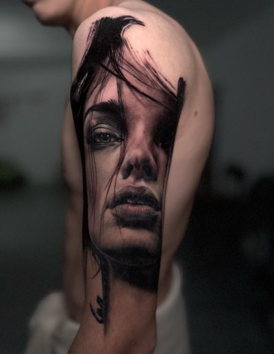 Realistisch portret van een vrouw met donker haar op de bovenarm.