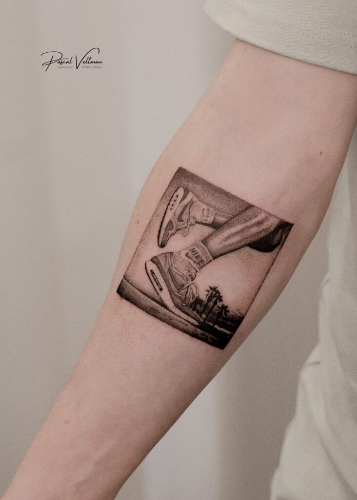 Realistische zwart-wit tattoo van Nike Air Max 1 sneakers in een vierkant kader.