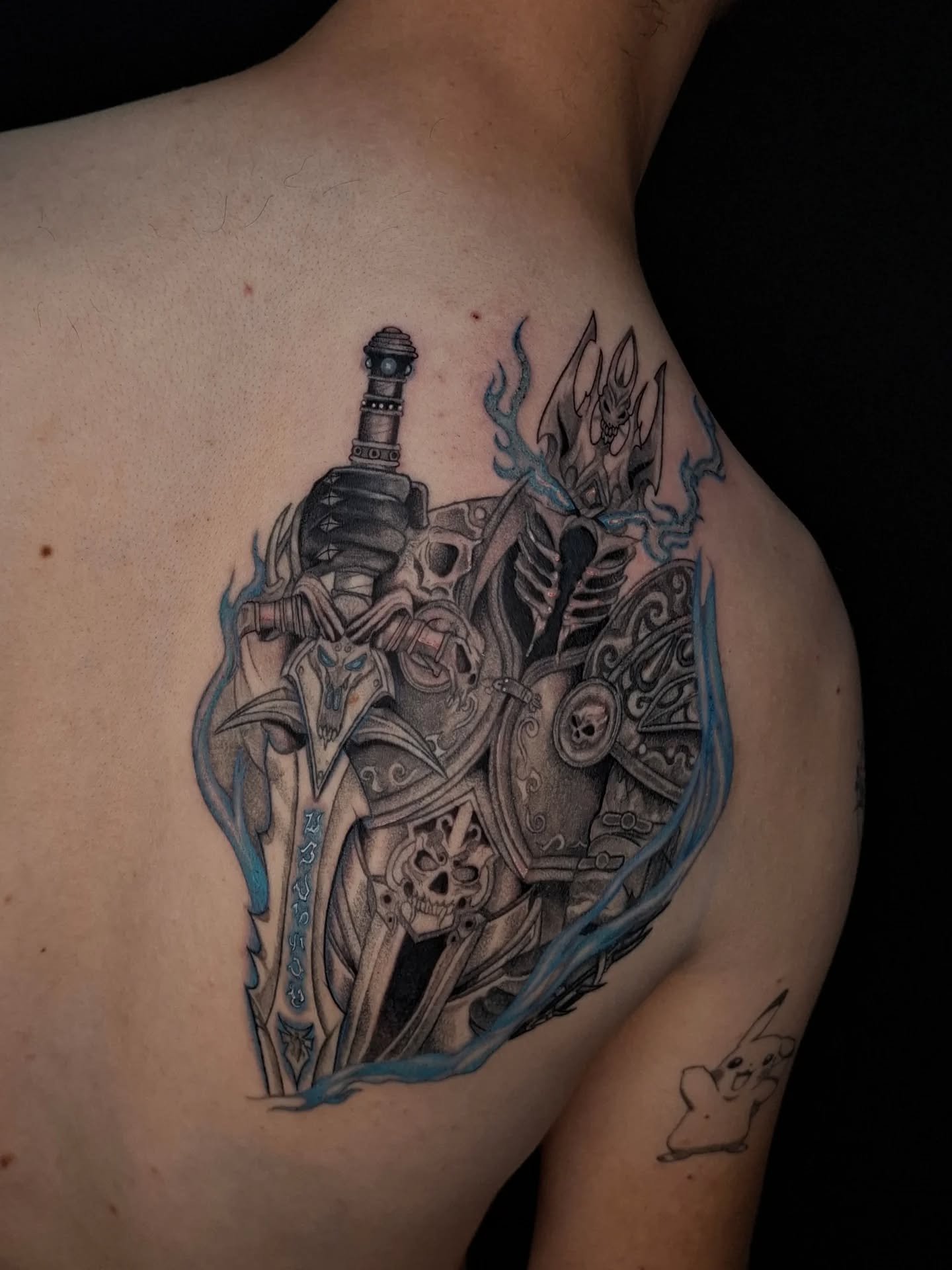 Gedetailleerde Lich King tattoo met Frostmourne zwaard en blauwe vlammen.