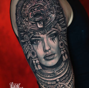 Realistisch portret van een vrouw met een Azteekse hoofdtooi op de bovenarm.