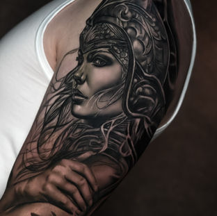 Realistisch portret van een vrouwelijke krijger met helm op de bovenarm.