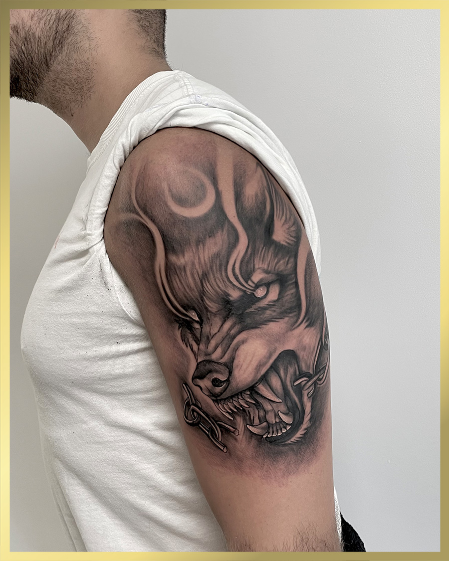 Realistische wolf met ketting en vlammen op bovenarm.