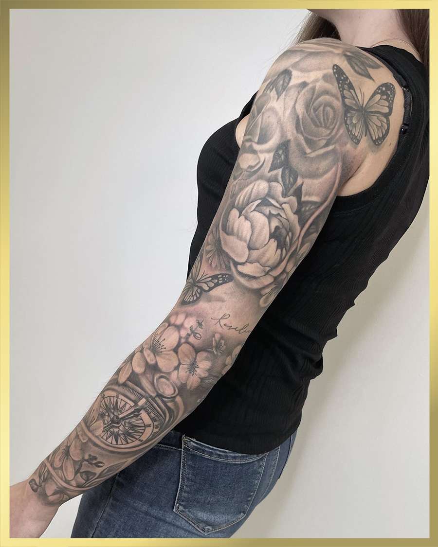 Zwart-wit sleeve met rozen, pioenrozen, vlinders en een kompas.