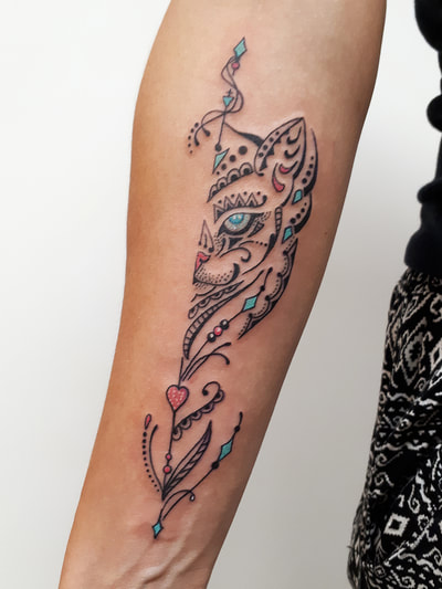 Illustratieve kattenkop met ornamenten en kleuraccenten op onderarm.