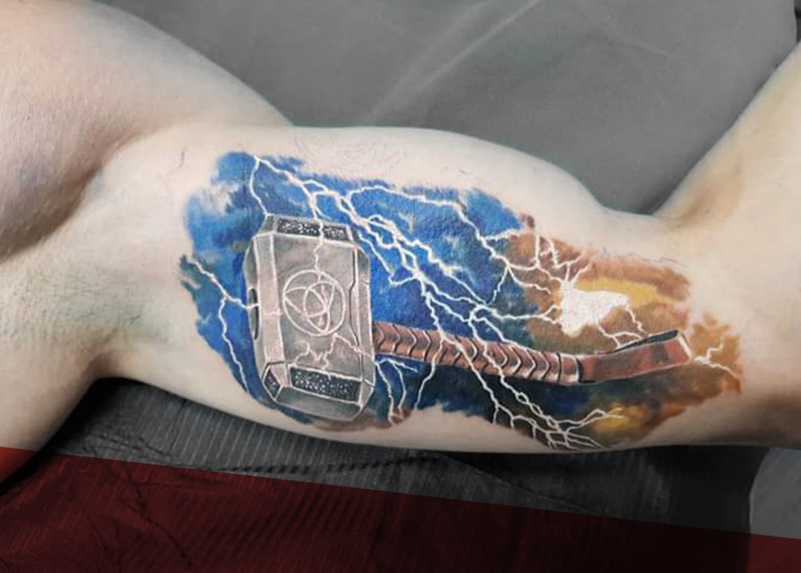 Realistische Thor's hamer (Mjölnir) met bliksem en aquarel op de bovenarm.