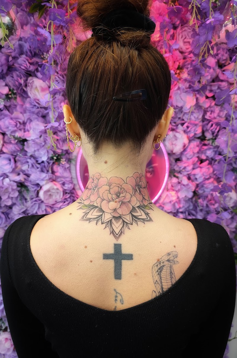 Bloemen mandala nek tattoo, kruis en slang op bovenrug.