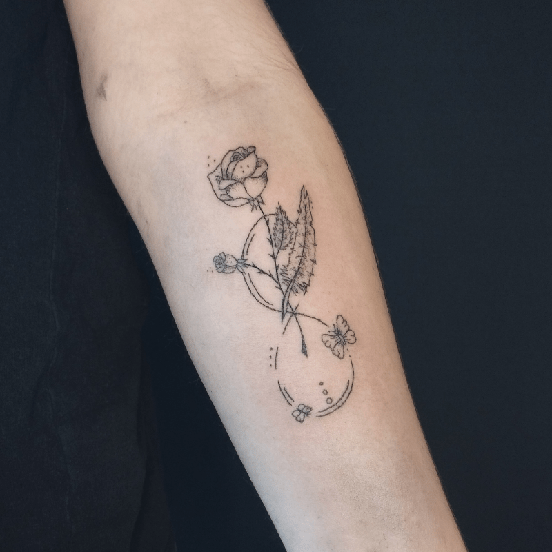 Fineline tattoo van een roos met oneindigheidssymbool en vlinders op de onderarm.