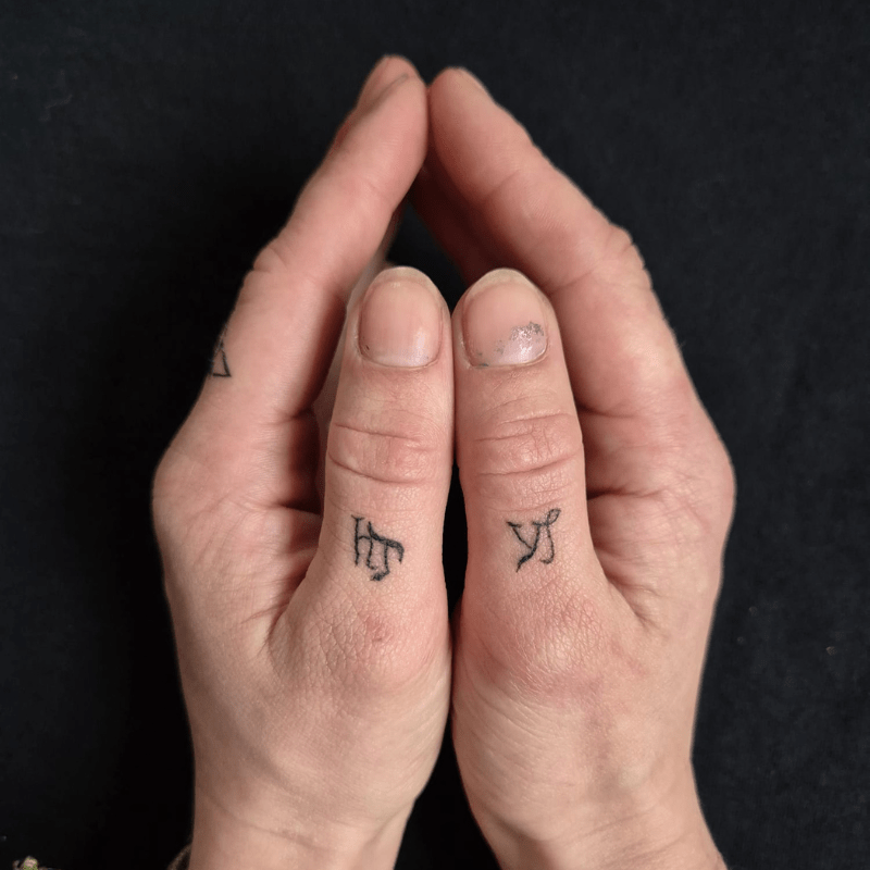 Twee kleine runen of symbolen op de duimen.