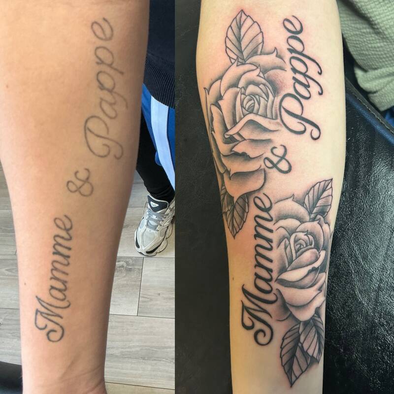Cover-up tattoo van tekst 'Mamme & Pappe' met twee rozen in blackwork stijl.