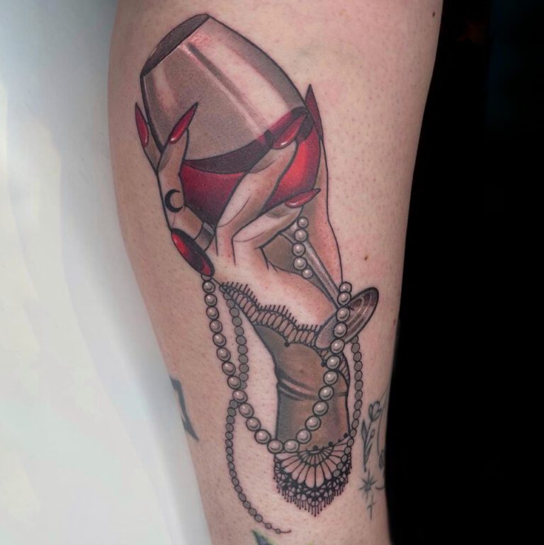 Neo-traditionele hand met rodewijnglas, parels en kant.