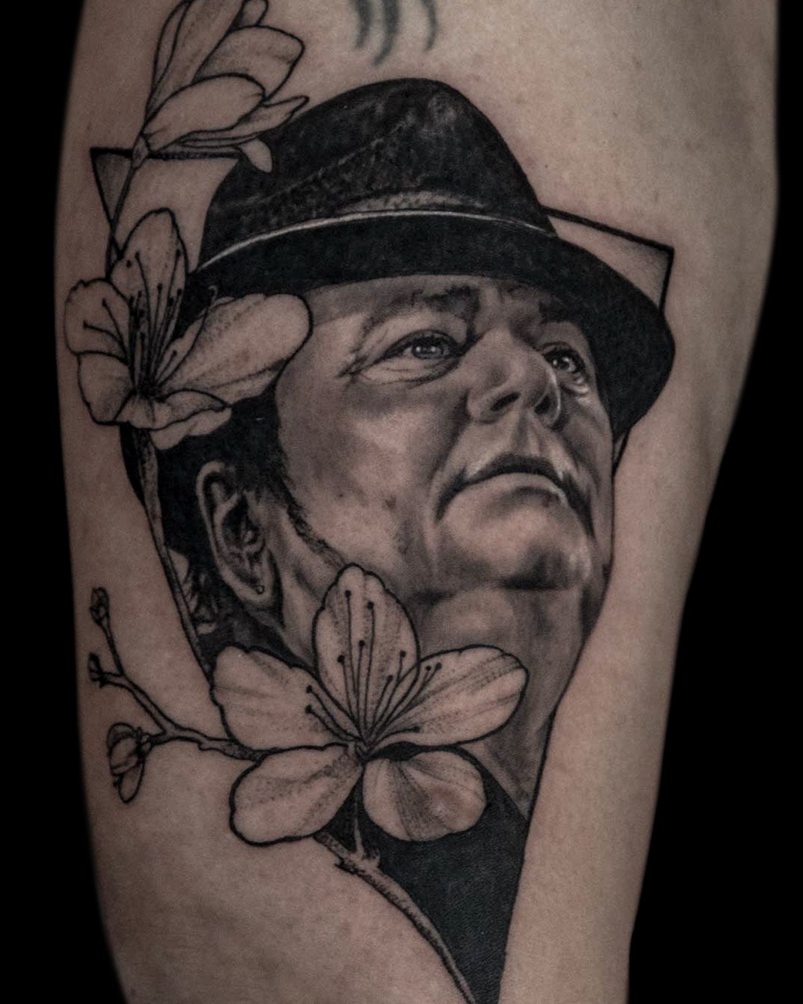 Realistisch portret van een man met hoed en bloemen.