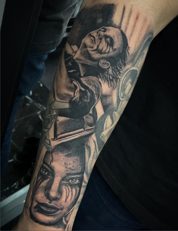 Realistische zwart-wit tattoo van Joker en een vrouw op een arm.