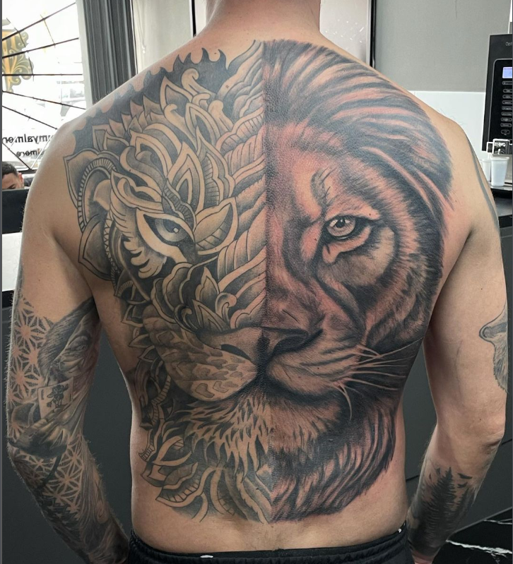 Grote rugtattoo, half realistische leeuw, half mandala patroon.