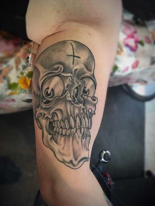 Zwart-wit schedel met grote, starende ogen en een kruis op het voorhoofd.