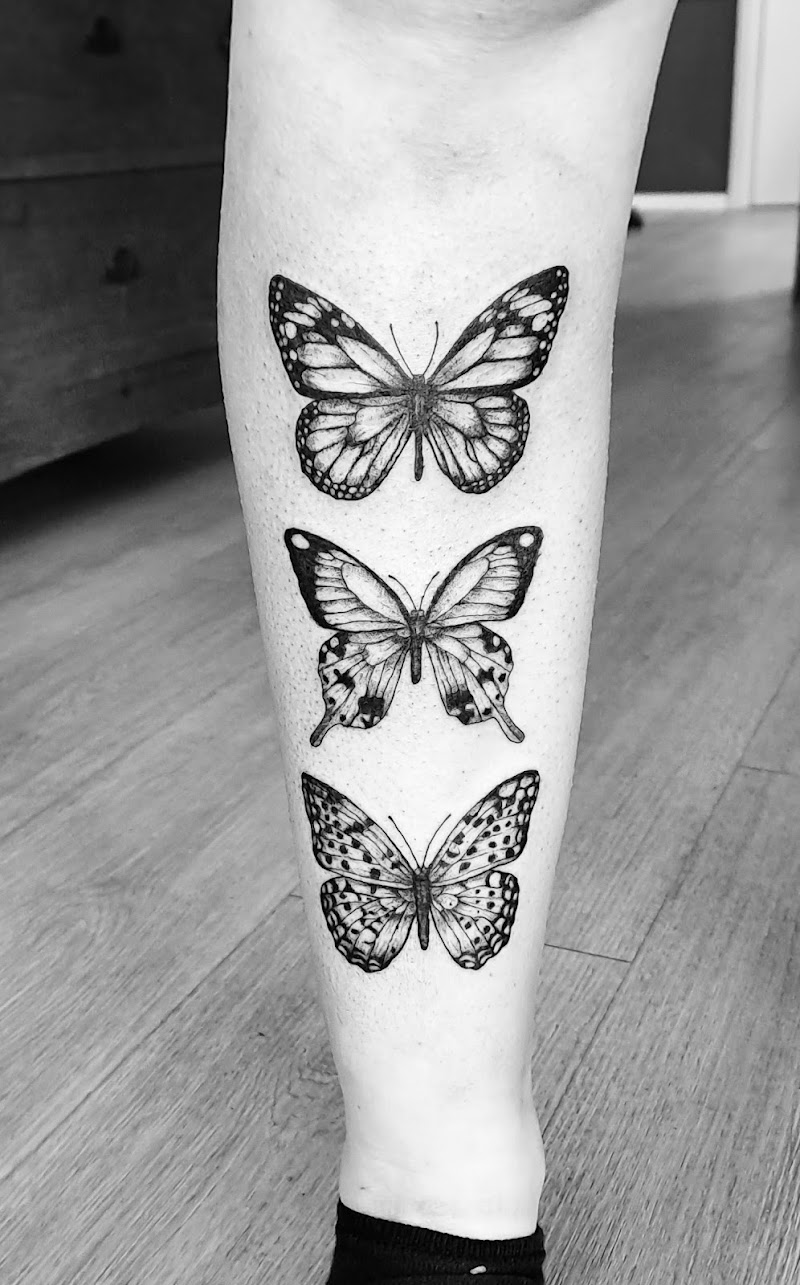 Drie gedetailleerde zwart-wit vlinders op het onderbeen.