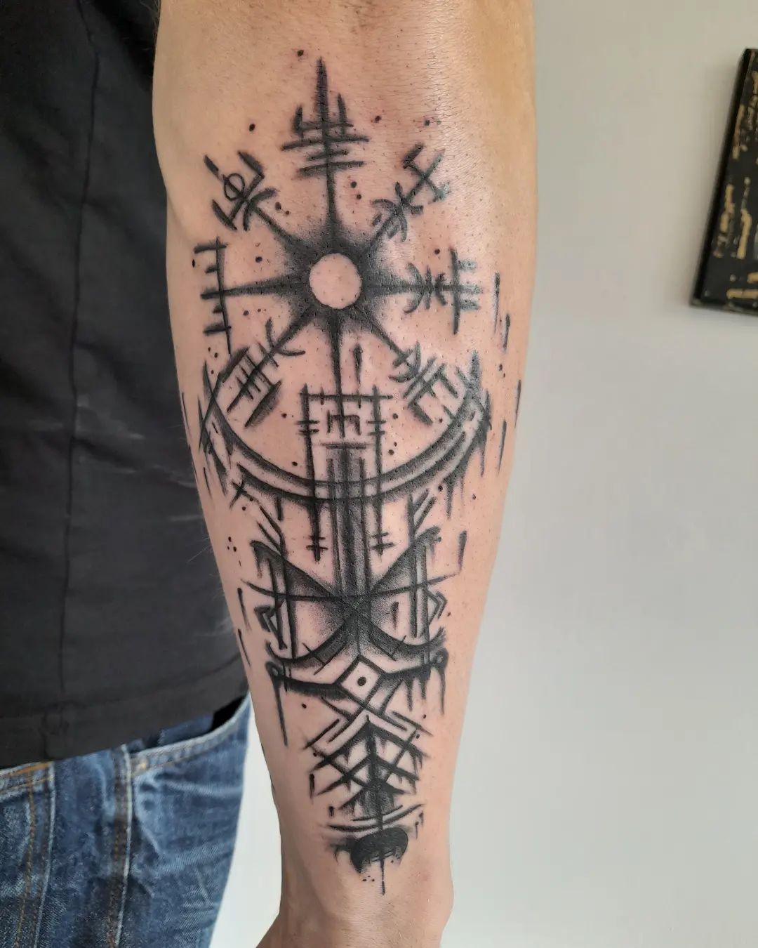 Blackwork tattoo van een Vegvisir en runen op de onderarm.