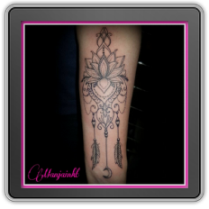 Fineline lotus met ornamenten, veren en maantje op onderarm.