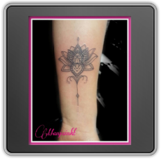 Fineline lotusbloem met ornamenten op onderarm.