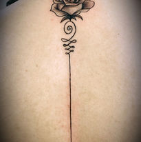 Fineline roos met unalome symbool op de rug.