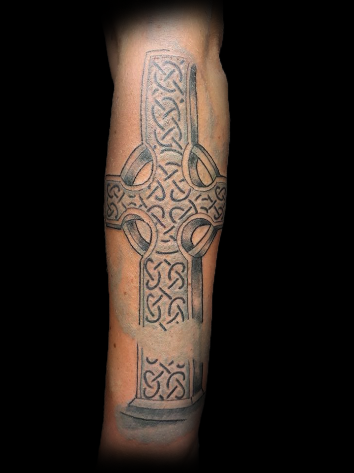 Groot Keltisch kruis tattoo op onderarm, zwart-wit.