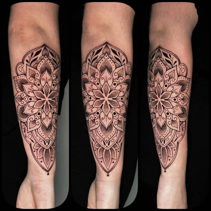 Gedetailleerde mandala tattoo met dotwork op de onderarm.