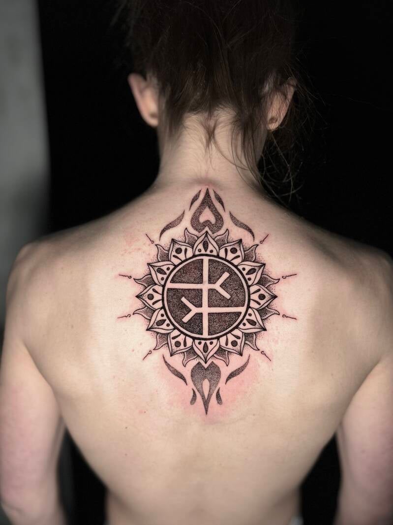 Grote dotwork mandala met runen op de bovenrug.