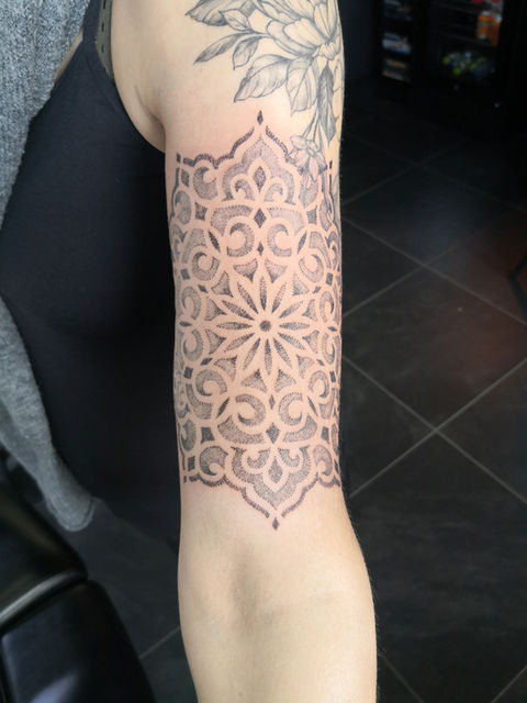 Grote dotwork mandala tattoo op de bovenarm.