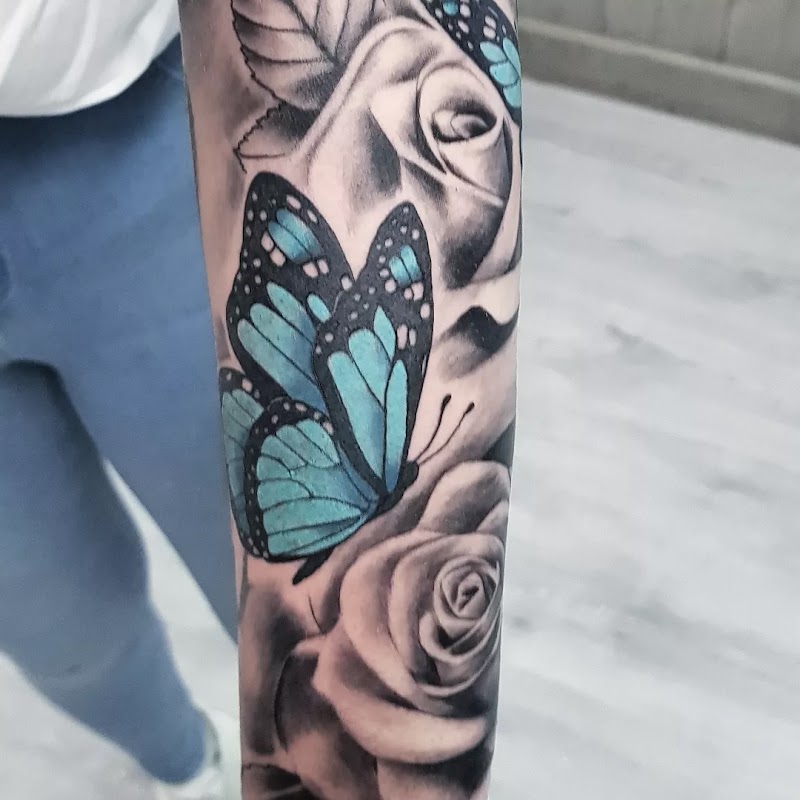 Blauwe vlinder met zwart-grijze rozen op onderarm.