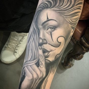 Realistisch portret van een vrouw met clownsmake-up en vinger voor de mond.