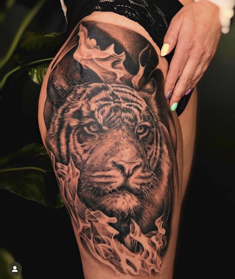 Realistische tijgerkop met rook op bovenbeen.