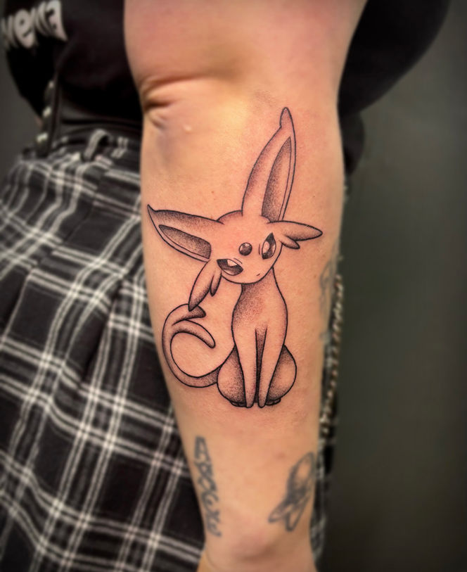Dotwork Espeon Pokémon tattoo op de onderarm.