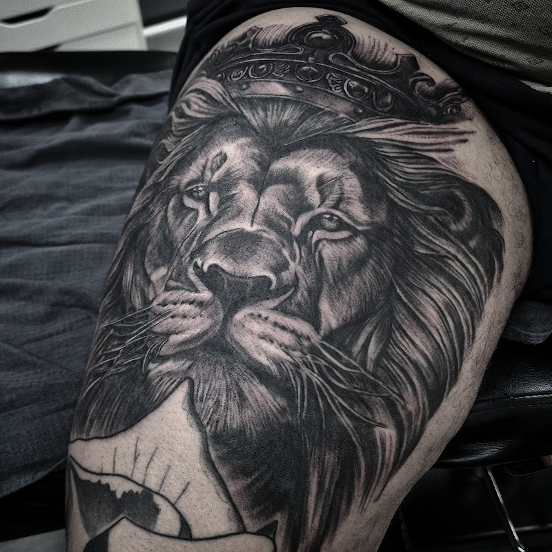 Realistische leeuw met kroon op bovenbeen.