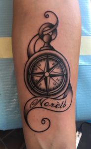 Blackwork kompas met naam 'Norèll' in een sierlijke banner.